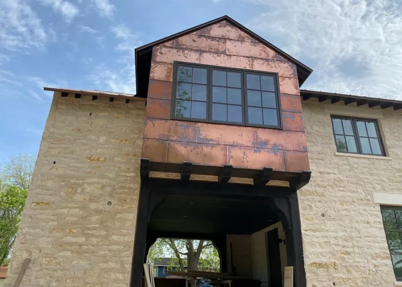 Copper metal panel facade on a stone building for Skylight Installation in Chain Lake